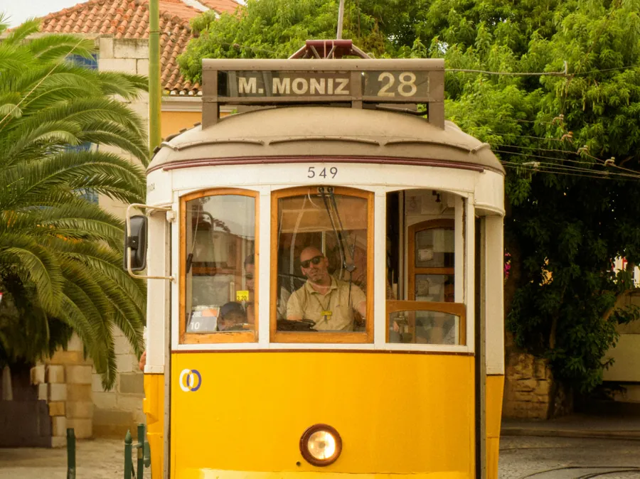 Front view of a historic yellow Tram 28 in Lisbon
